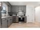Renovated kitchen boasts stainless appliances, gray cabinets, granite counters, and laminate flooring at 204 Valley Ct, Selma, NC 27576