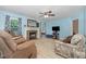 Warm living room with light blue walls, modern flooring, and brick fireplace at 204 Valley Ct, Selma, NC 27576