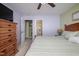 A bright main bedroom with a ceiling fan and wooden furniture leading to the bathroom at 205 Cedar Dr, Zebulon, NC 27597