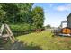 A lush backyard boasts green grass, mature trees, a playset, a chicken coop and privacy fence at 206 Vandercroft Way, Bunnlevel, NC 28323
