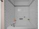 A tiled bath tub in a bathroom has a white tiled wall with decorative tile accents and chrome fixtures at 206 Vandercroft Way, Bunnlevel, NC 28323