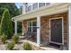 Inviting front porch with stone accents, seating, and a welcoming door, creating a warm and inviting entry at 206 Vandercroft Way, Bunnlevel, NC 28323