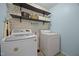 The laundry room includes modern washer and dryer units and shelving for storage at 206 Vandercroft Way, Bunnlevel, NC 28323