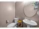 Cozy powder room featuring a pedestal sink, decorative mirror, and neutral color palette, adding a touch of elegance at 206 Vandercroft Way, Bunnlevel, NC 28323