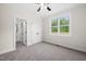 Inviting bedroom with plush carpet, a ceiling fan, a window, and a view into an attached bathroom at 225 Whistlers Cv, Louisburg, NC 27549