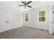 Bright bedroom with carpeting, a ceiling fan, ample closet space, and natural light from two windows at 225 Whistlers Cv, Louisburg, NC 27549