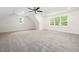 Spacious bedroom with neutral carpet, a ceiling fan, and a view of surrounding greenery through large windows at 225 Whistlers Cv, Louisburg, NC 27549