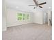 Large bonus room with neutral carpet, a ceiling fan, and natural light from the surrounding green space at 225 Whistlers Cv, Louisburg, NC 27549