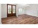 Bright dining room featuring wood floors, modern wainscoting, elegant lighting and charming double glass doors at 225 Whistlers Cv, Louisburg, NC 27549