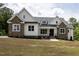 Beautiful home with stone and white siding, a covered porch, and professional landscaping at 225 Whistlers Cv, Louisburg, NC 27549