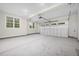 Spacious two-car garage featuring bright lighting, multiple windows, and an automatic door opener at 225 Whistlers Cv, Louisburg, NC 27549