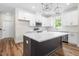 Modern kitchen with white cabinets, stainless steel appliances, white countertops and spacious center island at 225 Whistlers Cv, Louisburg, NC 27549