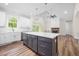 Open-concept kitchen features a large island, modern lighting, and seamless transition to the cozy living room at 225 Whistlers Cv, Louisburg, NC 27549