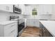 Modern kitchen boasts stainless steel appliances, white cabinets, white countertops and wood floors at 225 Whistlers Cv, Louisburg, NC 27549