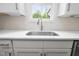 Bright kitchen sink features white countertops, scalloped backsplash, and a large window with natural light at 225 Whistlers Cv, Louisburg, NC 27549