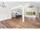 Open living area with wood floors, fireplace, abundant natural light, and kitchen view at 225 Whistlers Cv, Louisburg, NC 27549
