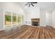 Bright living room features a fireplace, custom shelving, sliding doors to a screened porch, and wood flooring at 225 Whistlers Cv, Louisburg, NC 27549