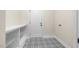 Practical mudroom with shelving, storage, and eye-catching patterned tile flooring at the entry at 225 Whistlers Cv, Louisburg, NC 27549