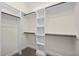Bright and spacious walk-in closet featuring ample shelving and wooden clothing rods for optimal storage and organization at 225 Whistlers Cv, Louisburg, NC 27549