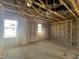 A room under construction with exposed beams, insulation, framed walls, and sunlit windows at 236 Norman Ave, Lillington, NC 27546