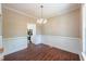 Bright dining room with wainscoting, hardwood floors, and a modern chandelier at 2430 Josephine Rd, Garner, NC 27529
