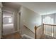 Upstairs hallway with wood railing and view into a sunlit room through an open door at 2430 Josephine Rd, Garner, NC 27529