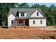Two-story home with a charming covered porch and a mix of brick and siding exterior at 25 Autumnwood Ln, Spring Hope, NC 27882