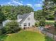 Aerial view of the home with a large manicured lawn, fire pit, fenced in back yard, and covered deck at 255 Morris Rd, Pittsboro, NC 27312