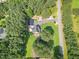 Aerial view of the property with a long driveway, a detached garage, and surrounded by lush forest at 255 Morris Rd, Pittsboro, NC 27312