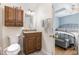 Well-lit bathroom featuring wood cabinets, granite countertop, and view into bedroom at 255 Morris Rd, Pittsboro, NC 27312