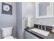Modern half-bathroom features a stylish vanity with a black countertop and gray walls at 255 Morris Rd, Pittsboro, NC 27312
