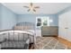 Comfortable bedroom with hardwood floors, ceiling fan, and large window providing natural light at 255 Morris Rd, Pittsboro, NC 27312