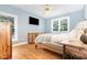 A serene bedroom with light blue walls, hardwood floors, and natural wood furniture at 255 Morris Rd, Pittsboro, NC 27312