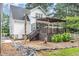 Exterior view of the back of the home, with a deck and patio area and well maintained landscaping at 255 Morris Rd, Pittsboro, NC 27312
