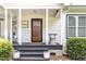 Welcoming front porch with a decorative welcome sign, plants, and black trim at 255 Morris Rd, Pittsboro, NC 27312