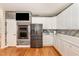 A well-appointed kitchen features white cabinets, stainless appliances, and wooden accent walls at 255 Morris Rd, Pittsboro, NC 27312