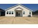 Rear view of a one-story home with siding, white trim, a patio and a plain yard under construction at 256 Norman Ave, Lillington, NC 27546