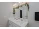 Bright bathroom with a double sink vanity, decorative mirror, and modern fixtures at 2586 Lacey Holt Rd, Graham, NC 27253