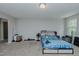 A spacious bedroom with neutral carpet and light gray walls bathed in natural light from a window at 2586 Lacey Holt Rd, Graham, NC 27253