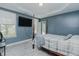 This bedroom features a four-post bed, TV, window, and stylish gray and blue color scheme at 2586 Lacey Holt Rd, Graham, NC 27253