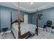 This bedroom features a four-post bed, tray ceiling, and stylish gray and blue color scheme at 2586 Lacey Holt Rd, Graham, NC 27253
