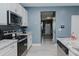 Open kitchen featuring stainless appliances, granite counters, and views of the home's entryway at 2586 Lacey Holt Rd, Graham, NC 27253