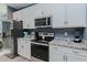 Bright kitchen featuring white cabinets, stainless steel appliances, and granite countertops at 2586 Lacey Holt Rd, Graham, NC 27253