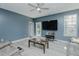 The bright living room features a ceiling fan, large TV, and outdoor access at 2586 Lacey Holt Rd, Graham, NC 27253