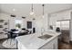 Open kitchen with a large center island, stainless appliances, and breakfast bar seating next to dining area at 2799 Cassius Dr, Apex, NC 27502