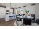 Bright eat-in kitchen featuring stainless appliances, white cabinets, pendant lighting, breakfast bar, and adjacent dining area at 2799 Cassius Dr, Apex, NC 27502