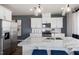 Modern kitchen features stainless steel appliances, white cabinetry, granite counters, and a spacious center island at 2799 Cassius Dr, Apex, NC 27502