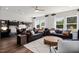 Open-concept living room featuring hardwood floors, large windows, modern decor, and comfortable seating at 2799 Cassius Dr, Apex, NC 27502