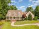 Aerial view of a house with a charming front porch, mature trees, and a winding walkway leading to the entrance at 2945 Chimney Hill Trl, Rocky Mount, NC 27804