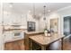 Bright kitchen boasts custom white cabinets, granite countertops, stainless appliances and central island at 2945 Chimney Hill Trl, Rocky Mount, NC 27804